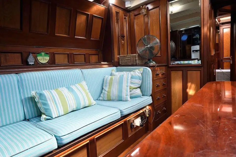 Close view of a striped saloon settee against panelled bulkhead and drawer stowage