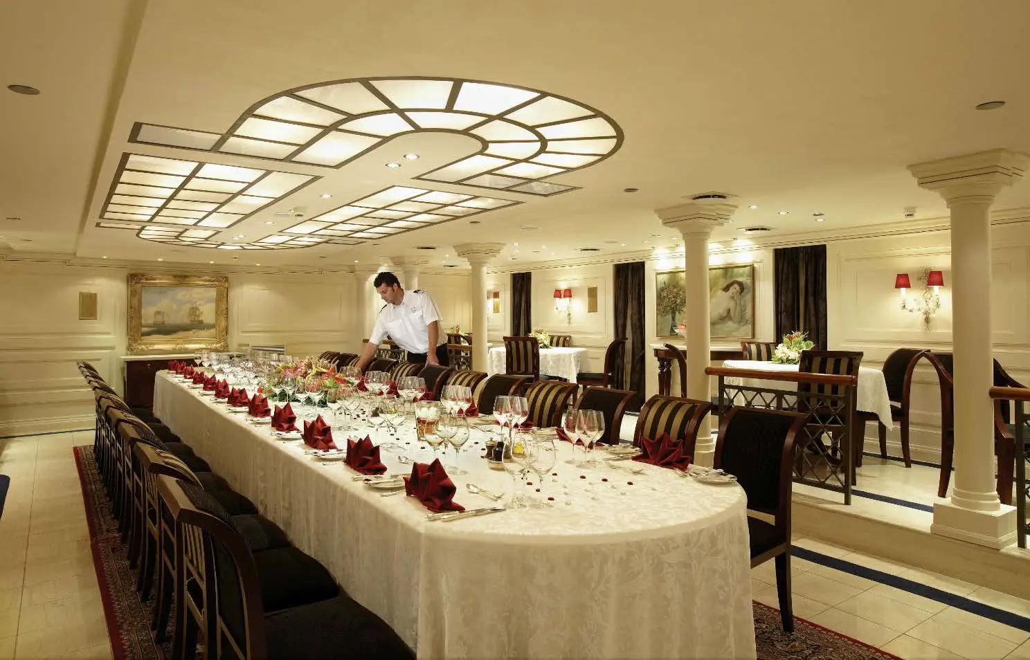 Dining table laid with glassware and linen