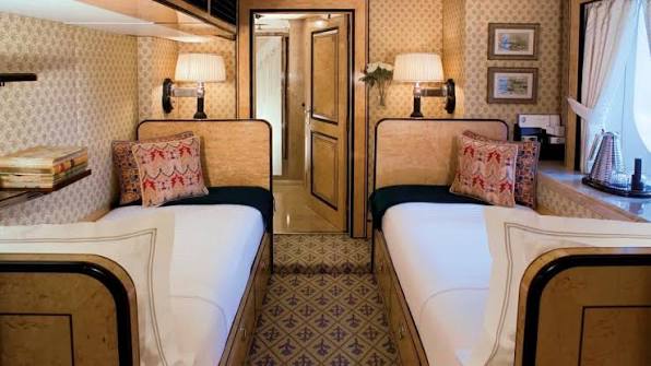 Twin cabin with matched beds, patterned wall covering and framed prints
