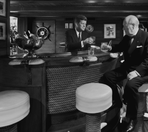 Two men in evening dress standing at the bar aboard the yacht Christina