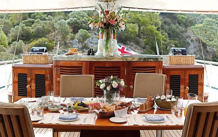 Deck table laid for lunch with a wooded shoreline behind