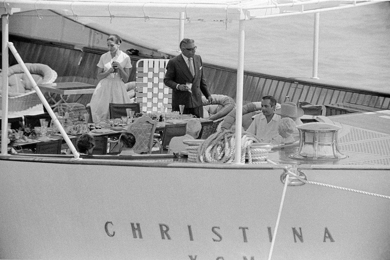 Group of guests seated at a table on the aft deck of the yacht Christina