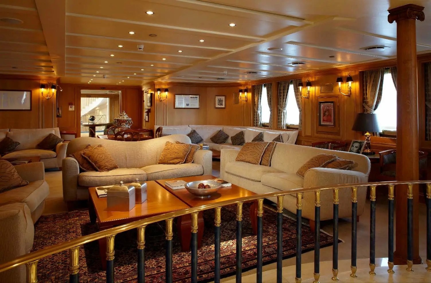Upper salon with sofas, occasional tables and panelled bulkheads