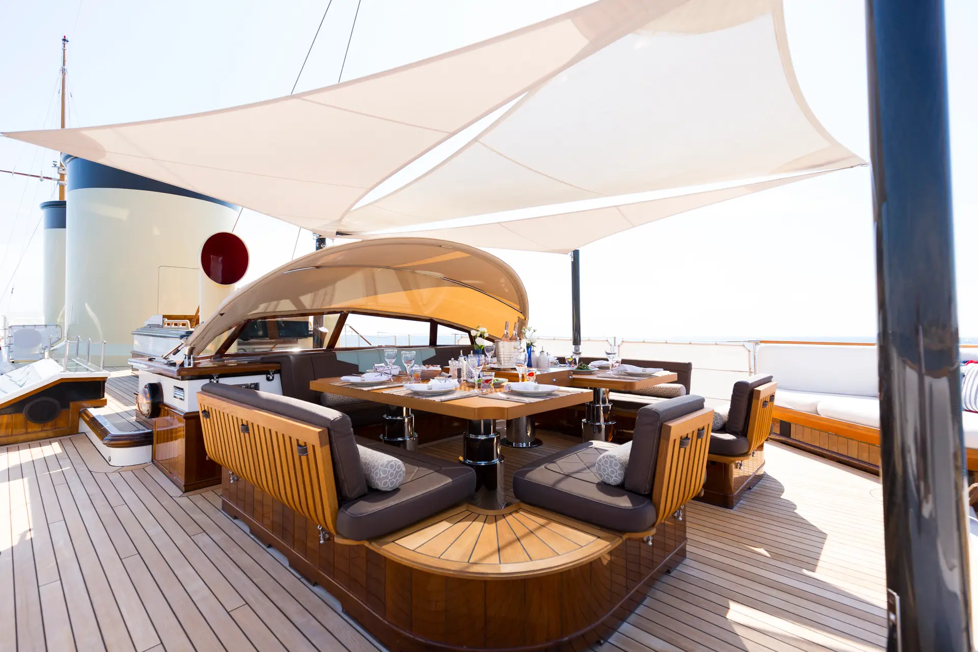 Deck dining area under white awnings beside the funnel