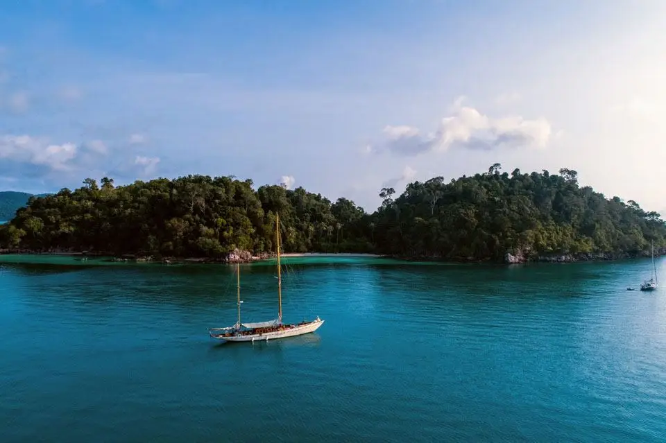 Rona at anchor in a sheltered tropical bay seen from the air