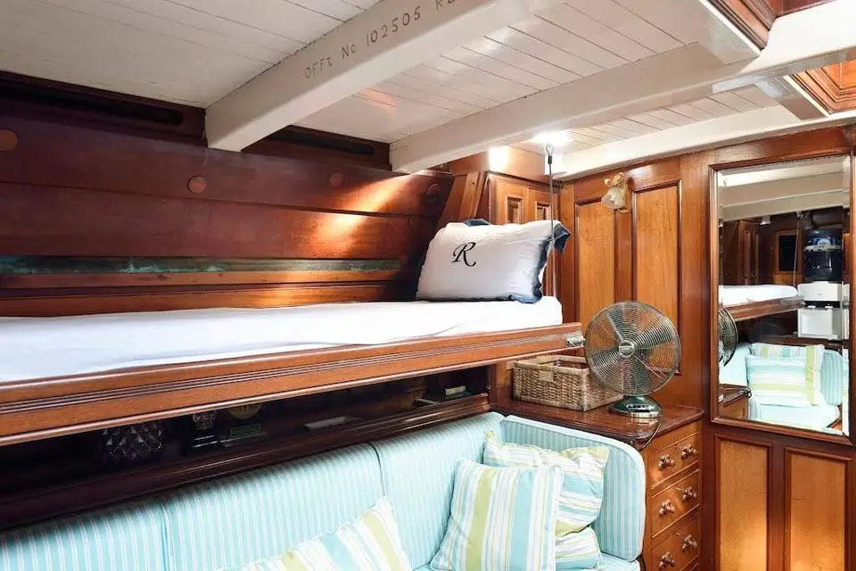 Panelled cabin with a raised berth, mirrored locker and striped settee