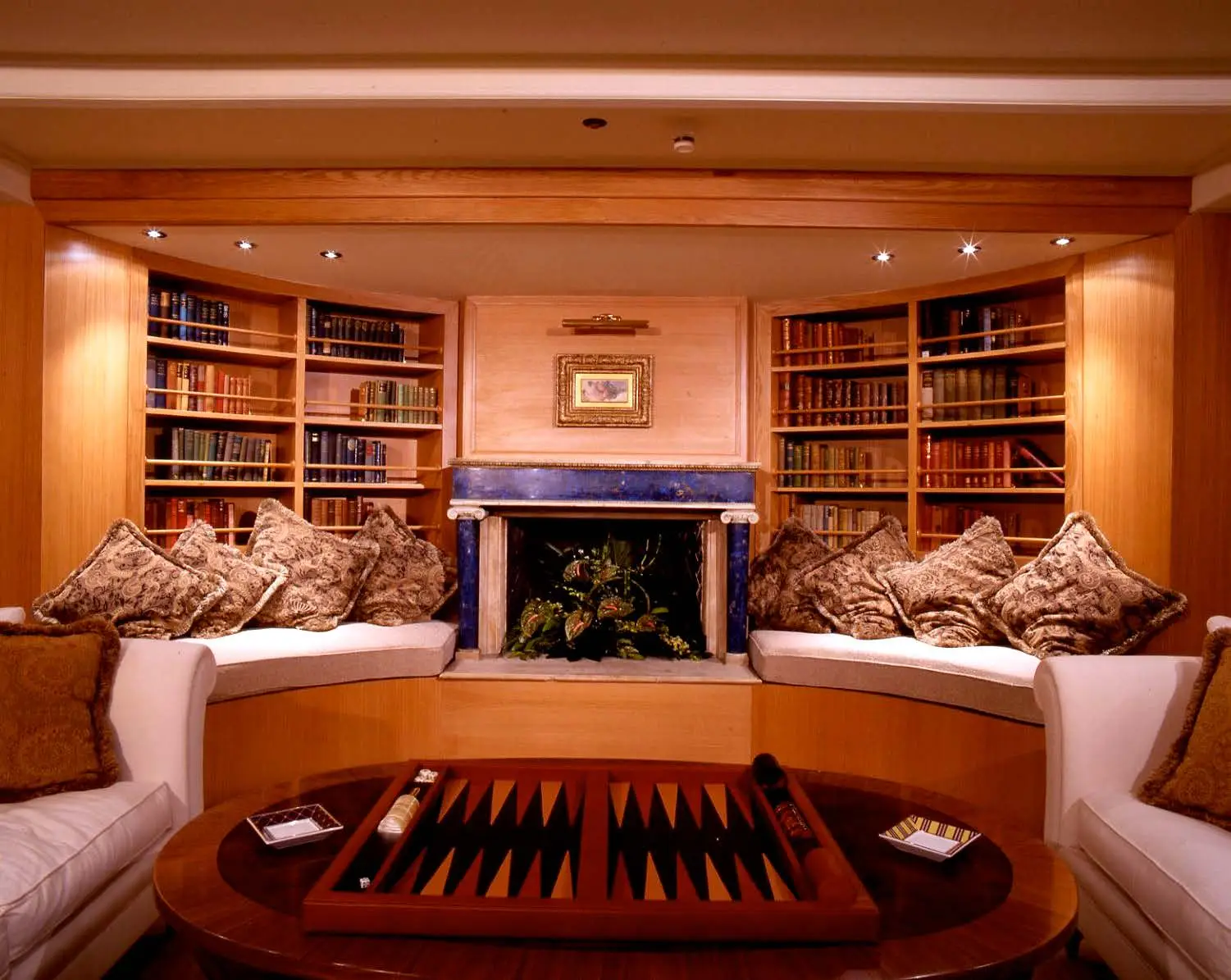 Library with bookshelves, armchairs and a fireplace