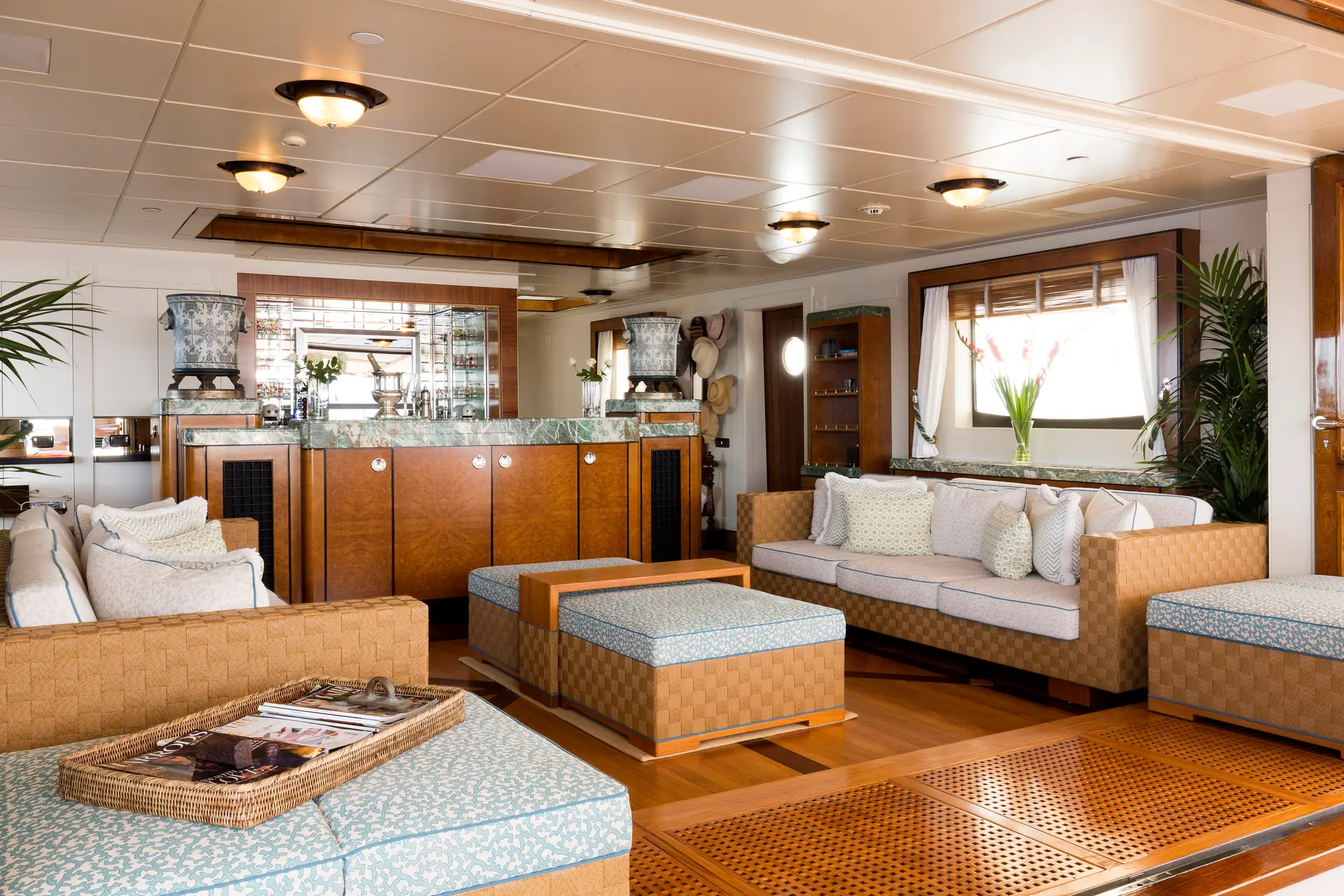 Panelled deck saloon with a marble-topped bar, woven upholstery and daylight windows