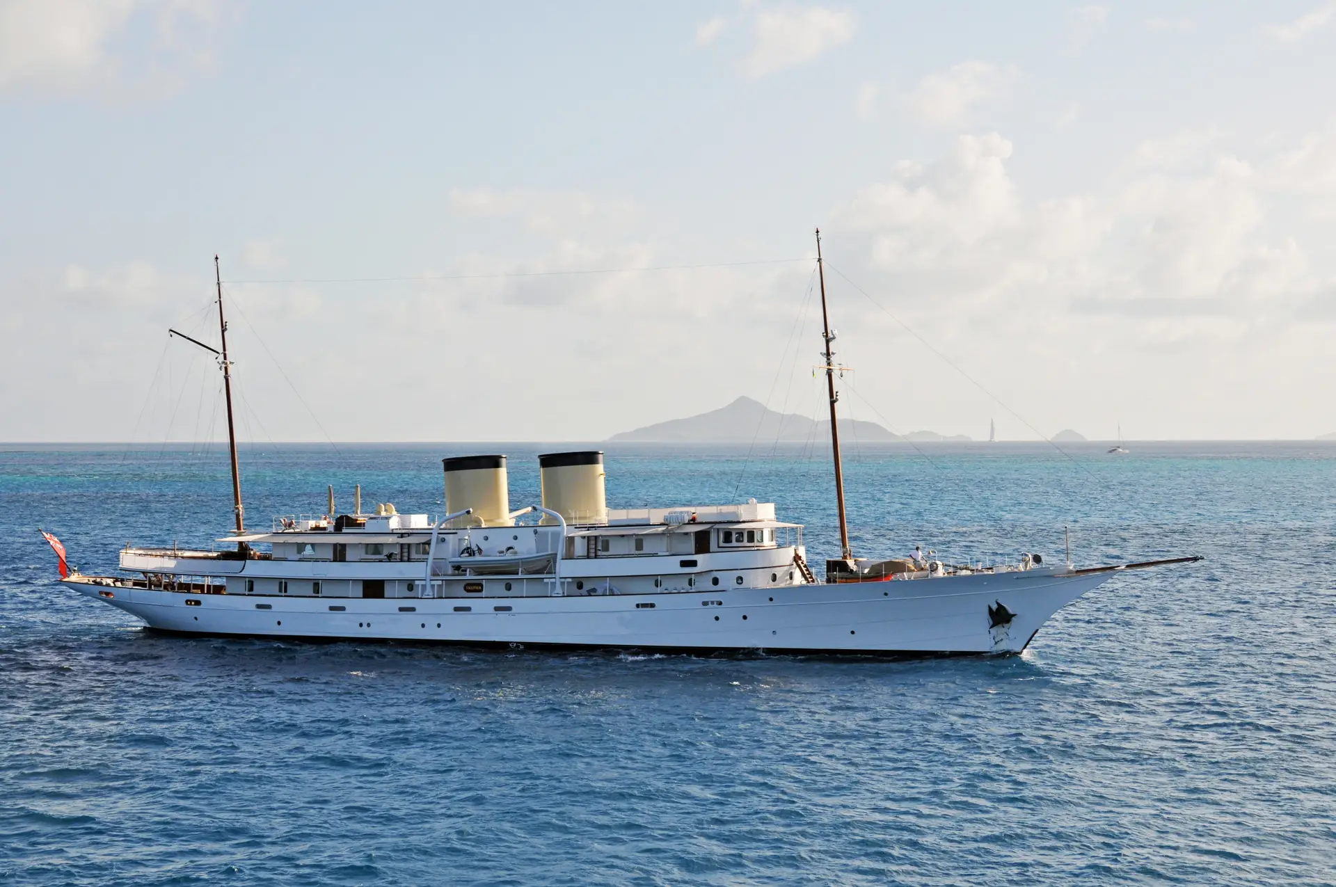 Talitha under way with a distant island peak on the horizon